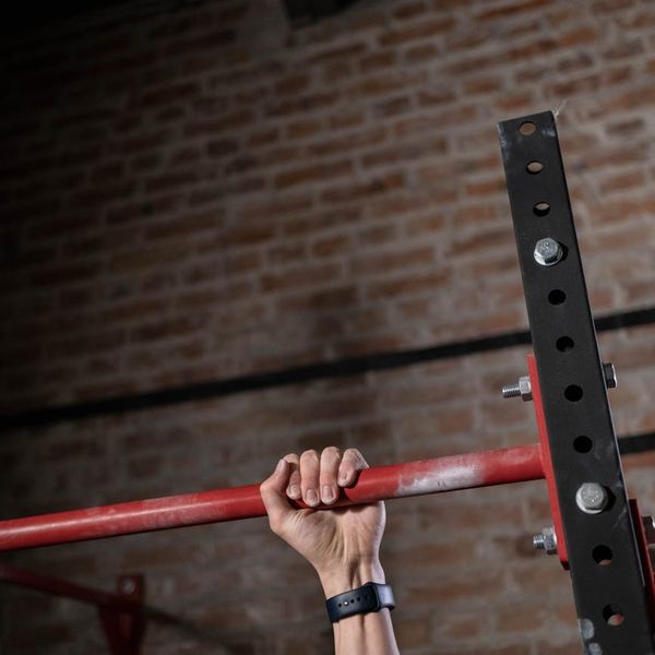 Close-up shot of a man's hands gripping a pull-up bar.